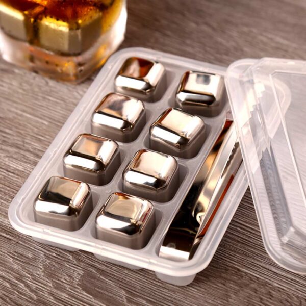 Pierres à whisky en forme de cube en inox avec une pince dans une boite sur une table